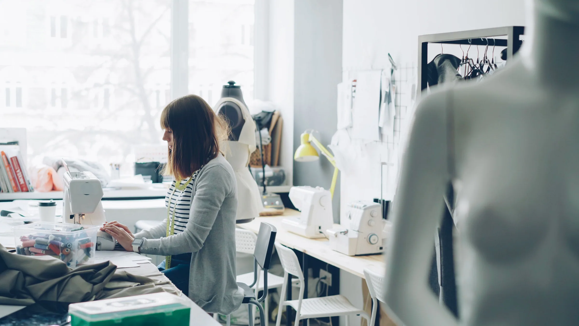 Designer sewing in a bright creative studio